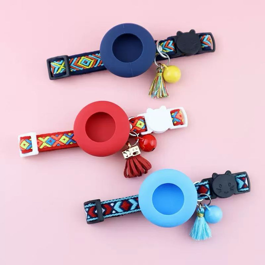 Three folk-woven AirTag cat collars in navy, crimson, and sky